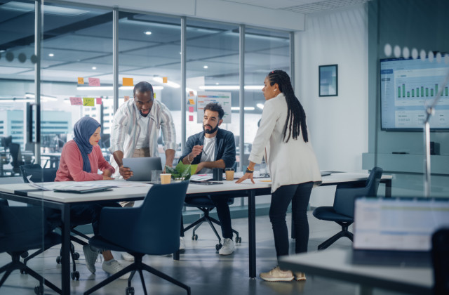 An image of four people having a business meeting at a table in an office