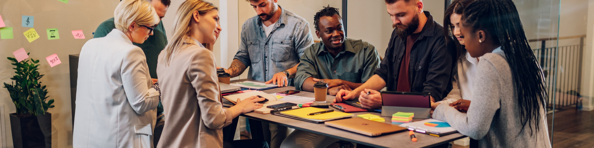 A group of people having a meeting at a table, talking and smiling